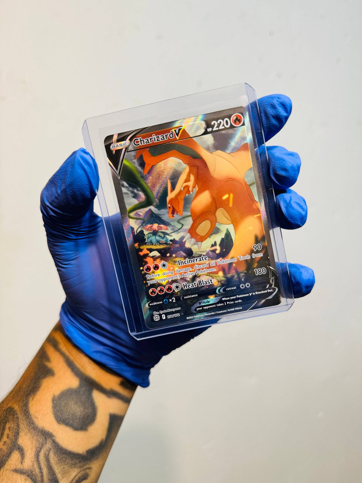 Charizard V Alternate Full Art Pokémon card from BlueGloveTCG with vibrant dragon artwork and detailed card design.